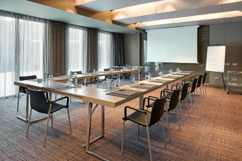 a conference room with tables and chairs and a screen at AC Hotel Sants by Marriott in Barcelona
