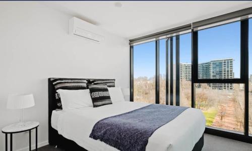a bedroom with a bed and a large window at City-Views-Stylish-2bed2bath in Canberra