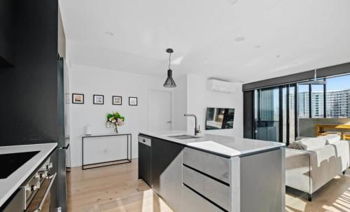a kitchen with a sink and a living room at City-Views-Stylish-2bed2bath in Canberra