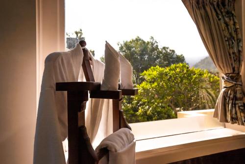 a robe on a window sill with a window view at The Solluna Resort in Marchula