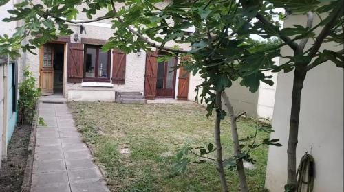 a small tree in front of a house at Maison Cosy avec jardin - Paris - 4 Pers - in Aulnay-sous-Bois