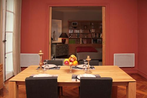 a dining room table with a bowl of fruit on it at Maison d'hôtes Bordeaux Centre Le Patio de l'Intendance in Bordeaux