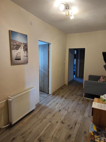 an empty living room with a couch and wooden floors at Veludo Apartments in Banská Bystrica