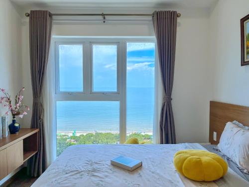 Un dormitorio con una cama con una ventana grande. en Mermaid seaview Vũng Tàu - Khang Apartment 1, en Vung Tau