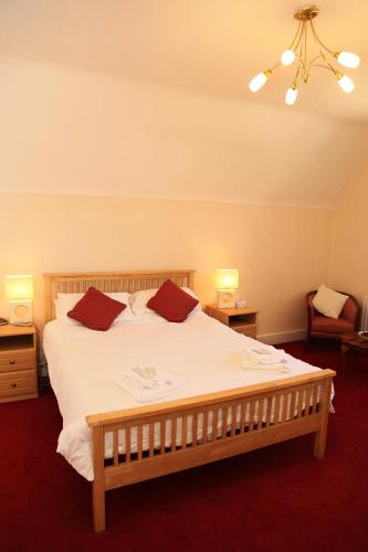a bedroom with a large white bed with two pillows at The Red Lion in Revesby