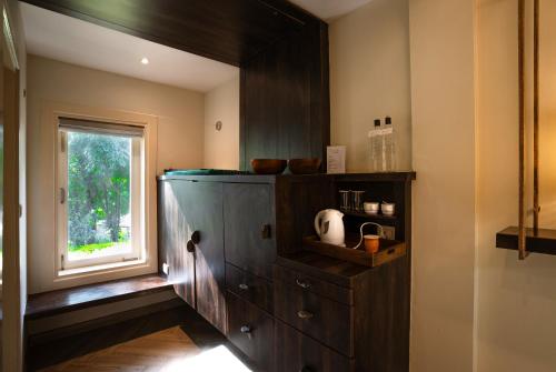 a kitchen with a wooden cabinet and a window at The Solluna Resort in Marchula