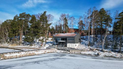 a house in the snow with a road in front at Hotel Rantapuisto in Helsinki