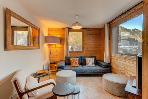 un salon avec un canapé et une fenêtre dans l'établissement APARTMENT KANDAHAR - Alpes Travel - Central Chamonix - Sleeps 4, aux Houches
