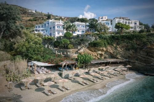 a group of chairs and umbrellas on a beach at Aneroussa Beach Hotel in Batsi