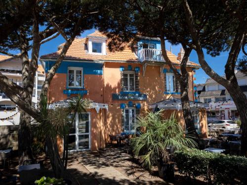 ein orangefarbenes Gebäude mit Bäumen davor in der Unterkunft La Villa Rose-Marie in Saint-Brevin-les-Pins