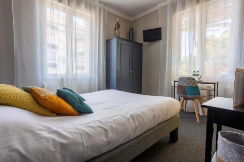 ein Schlafzimmer mit einem Bett mit Kissen darauf in der Unterkunft La Villa Rose-Marie in Saint-Brevin-les-Pins