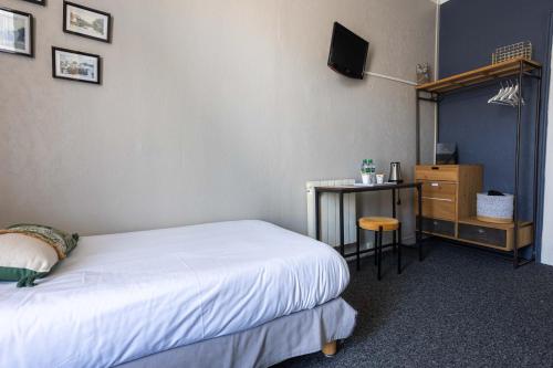 ein Schlafzimmer mit einem Bett und einem Schreibtisch mit einem Fernseher in der Unterkunft La Villa Rose-Marie in Saint-Brevin-les-Pins