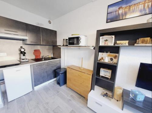 une cuisine avec des placards en acier inoxydable et un comptoir dans l'établissement Joli studio à deux pas de la mer, au Grau-du-Roi