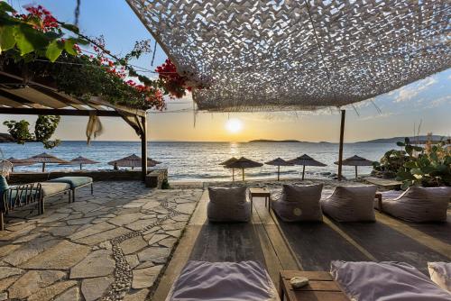 a beach with chairs and umbrellas and the ocean at Aneroussa Beach Hotel in Batsi