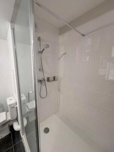une salle de bain avec une douche avec une porte vitrée dans l'établissement Grand studio neuf Bagneux proche transport métro 4 Paris, à Bagneux