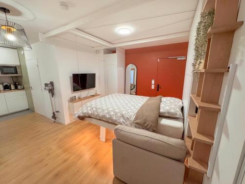 Un dormitorio con una cama y una sala de estar. en Grand studio neuf Bagneux proche transport métro 4 Paris, en Bagneux
