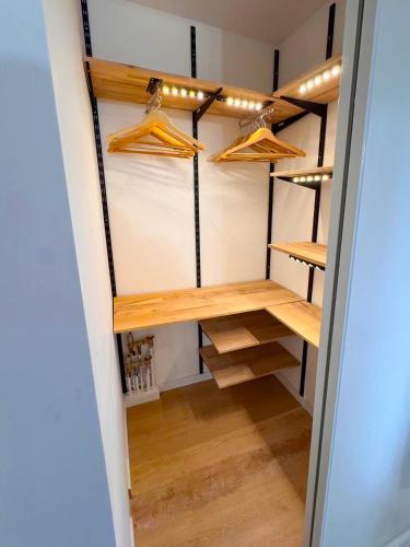 Elle comprend un dressing avec des étagères et des lampes en bois. dans l'établissement Grand studio neuf Bagneux proche transport métro 4 Paris, à Bagneux