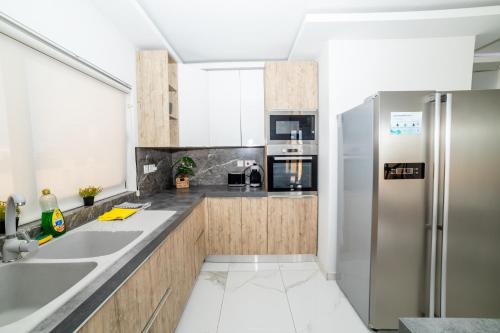 Una cocina con electrodomésticos de acero inoxidable y gabinetes de madera. en Peaceful Corner Penthouse 3 bed with views, en St Paul's Bay