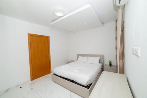 Un dormitorio con una cama en una habitación blanca. en Peaceful Corner Penthouse 3 bed with views, en St Paul's Bay
