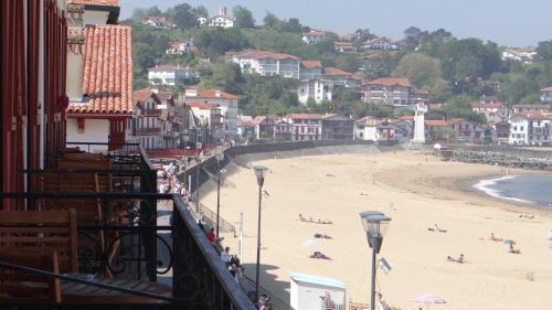 a view of a beach with people laying on the sand at Hôtel de la Plage - Saint Jean de Luz in Saint-Jean-de-Luz