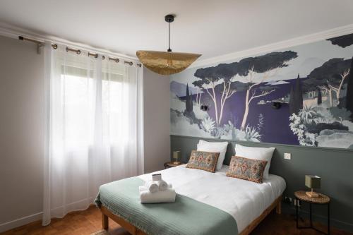 une chambre avec un lit avec un tableau sur le mur dans l'établissement L'Écrin de Pléneuf - Jolie maison avec 2000m2 de jardin, à Pléneuf-Val-André
