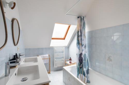 La salle de bains est pourvue d'un lavabo et d'une lucarne. dans l'établissement L'Écrin de Pléneuf - Jolie maison avec 2000m2 de jardin, à Pléneuf-Val-André