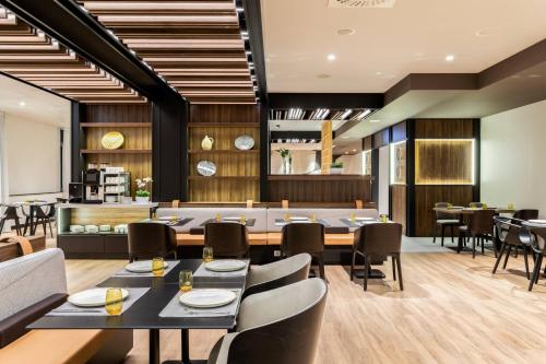 a restaurant with tables and chairs and a kitchen at AC Hotel by Marriott Bratislava Old Town in Bratislava