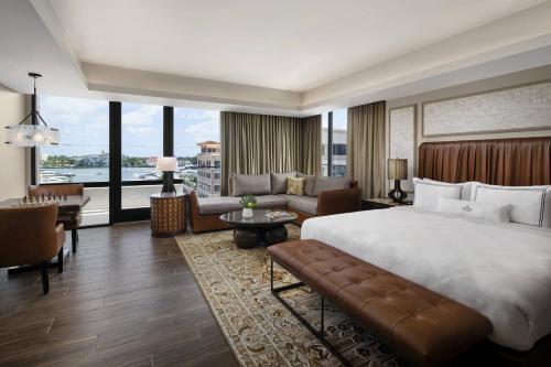 a bedroom with a large bed and a living room at The Ben, Autograph Collection in West Palm Beach
