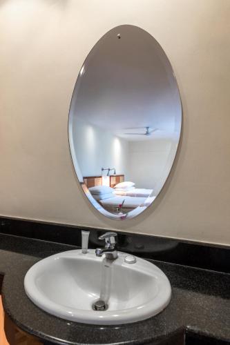 a bathroom sink with a round mirror above it at Best Western Nairobi Upper Hill in Nairobi