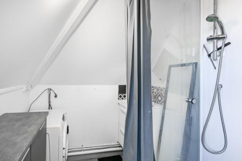 une douche avec un rideau de douche bleu dans une salle de bain dans l'établissement L'Évasion Normande - Appt à proximité de la plage, à Ouistreham