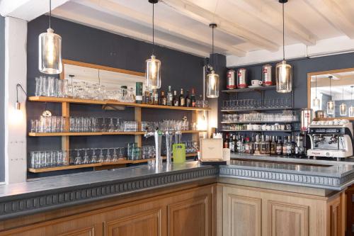 eine Bar mit Holzschränken und Regalen in der Unterkunft La Villa Rose-Marie in Saint-Brevin-les-Pins