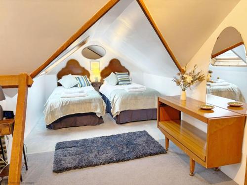 a attic bedroom with two beds and a desk at Warner Wood - Selsey in Selsey