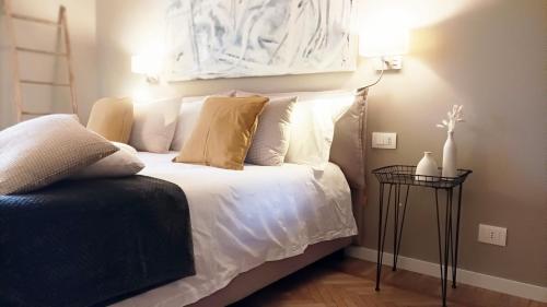 ビエッラにあるQuickHome - Le due Palmeの白いシーツと枕が備わったベッドのある寝室
