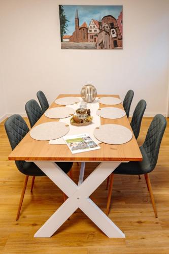 a table with chairs around it with a sandwich on it at Sonnenschein Hotel & Apartments in Heilbad Heiligenstadt