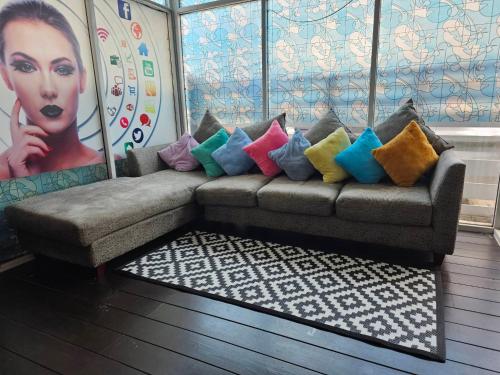 a couch with colorful pillows in a living room at ทาวเฮ้าส์ทั้งหลังใกล้สนามบินดอนเมือง 15 นาที in Ban Wat Pho Thong