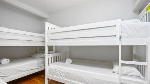 two white bunk beds in a white room at Sea Whisper in Metung