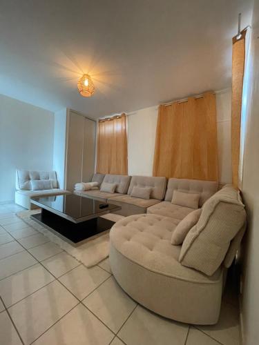 un salon avec un canapé et une table basse dans l'établissement Maison Confortable, à Saint-Martin-Belle-Roche