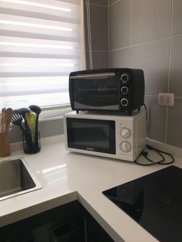 a microwave sitting on top of a kitchen counter at Casa Condominio Costa Quilén in Puchuncaví