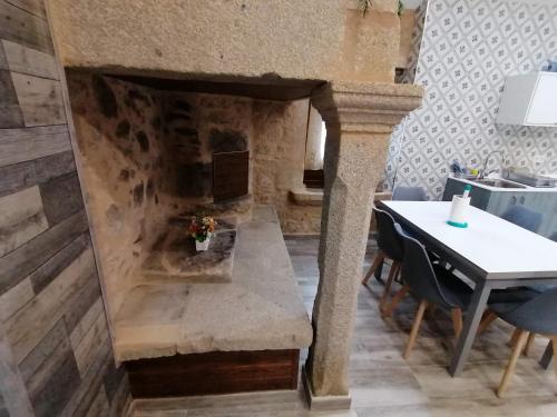 a dining room with a table and a stone fireplace at Casa da Corna by Cristian&Tamara "alquileres" in Pobra do Caramiñal