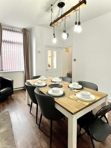 a dining room with a large wooden table and chairs at Modernised 3-bed home in Bamber Bridge, Preston in Bamber Bridge