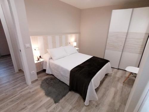 a bedroom with a large white bed and a window at Casa da Corna by Cristian&Tamara "alquileres" in Pobra do Caramiñal