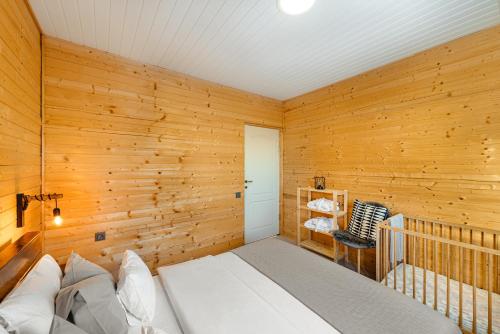 a room with a crib in a wooden wall at Apusenity- Refugiu modern în inima naturii, aproape de Cluj in Cluj-Napoca