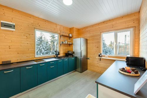 a kitchen with green cabinets and a refrigerator at Apusenity- Refugiu modern în inima naturii, aproape de Cluj in Cluj-Napoca