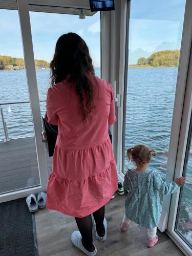 a woman and a little girl looking at the water at Seahome Pape in Flessenow