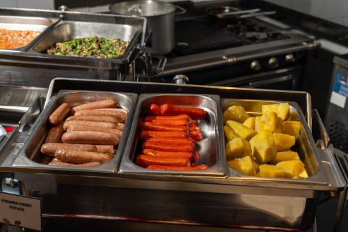 a tray of hot dogs and vegetables in a kitchen at Best Western Nairobi Upper Hill in Nairobi