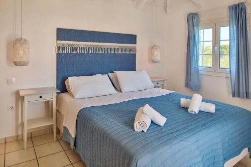 Un dormitorio con una cama azul con toallas. en Villa Lito Periyali, en Vasilikos