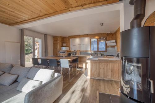 Il dispose d'une cuisine et d'un salon avec un canapé et un réfrigérateur. dans l'établissement Chalet 8 personnes, à Passy