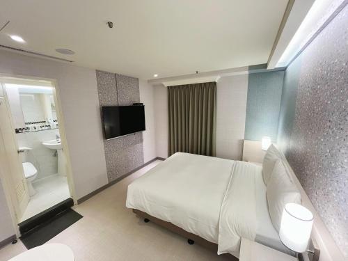 a hotel room with a bed and a bathroom at 新仕飯店-New City Hotel in Taipei