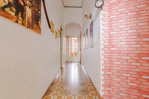 a hallway with a red brick wall and a tile floor at A 5 minuti da Lecce - DOMUS ANTIQUA in Lizzanello
