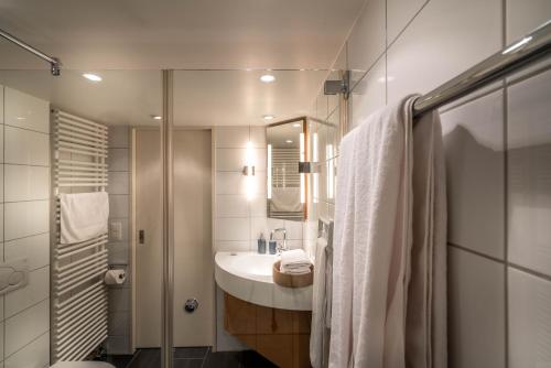 a white bathroom with a sink and a shower at Lake Side Location Bellevue in Zürich